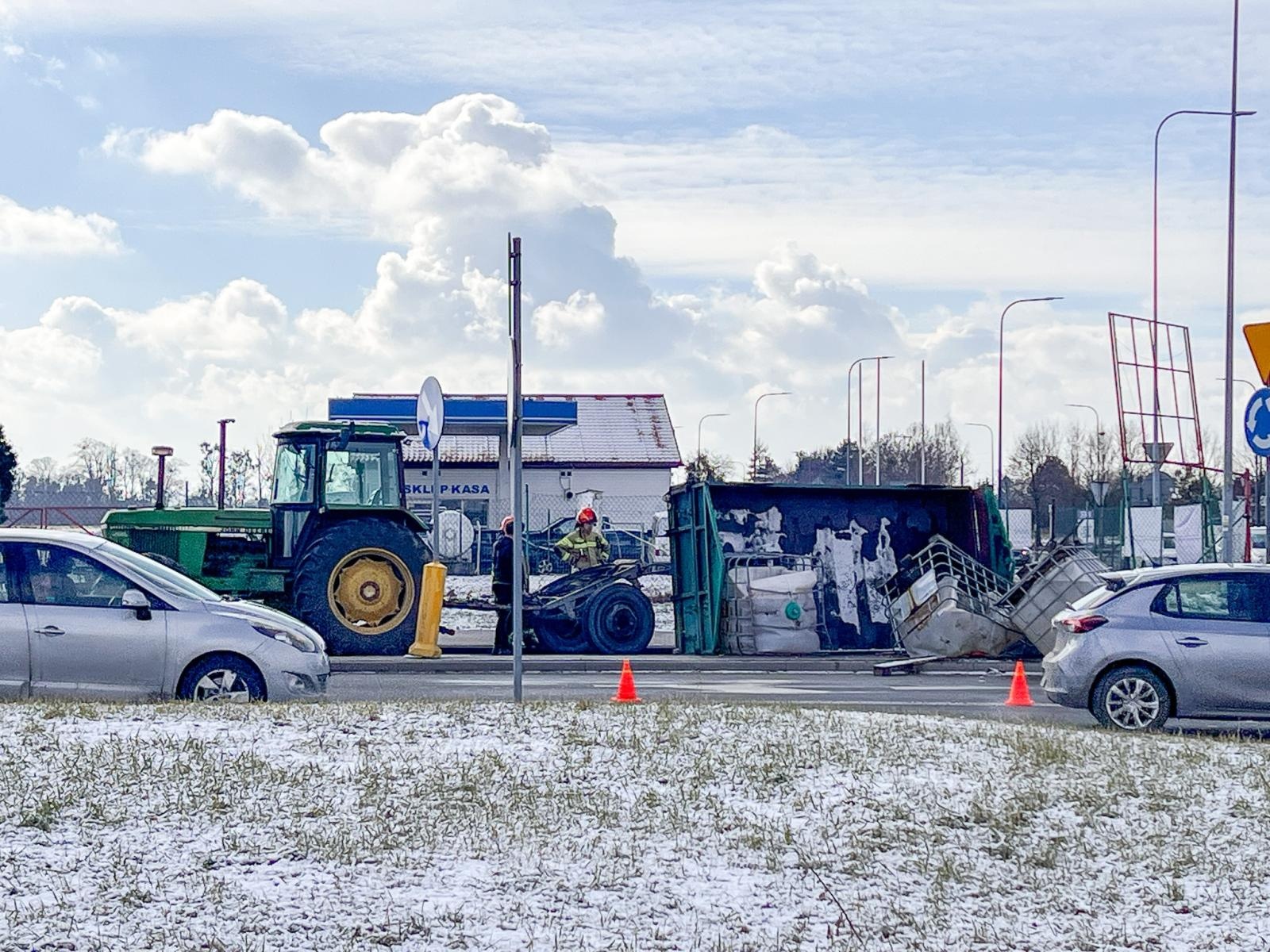 Zdjęcie w galerii na portalu naszraciborz.pl: Niebezpieczna sytuacja na rondzie Piaskowa – Rybnicka. Przyczepa przewróciła się, ładunek na jezdni [FOTO i WIDEO] wiadomości z regionu