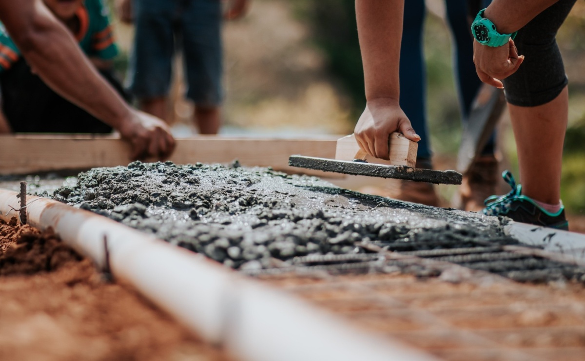 Ludzie przy budowie domu kładący cement