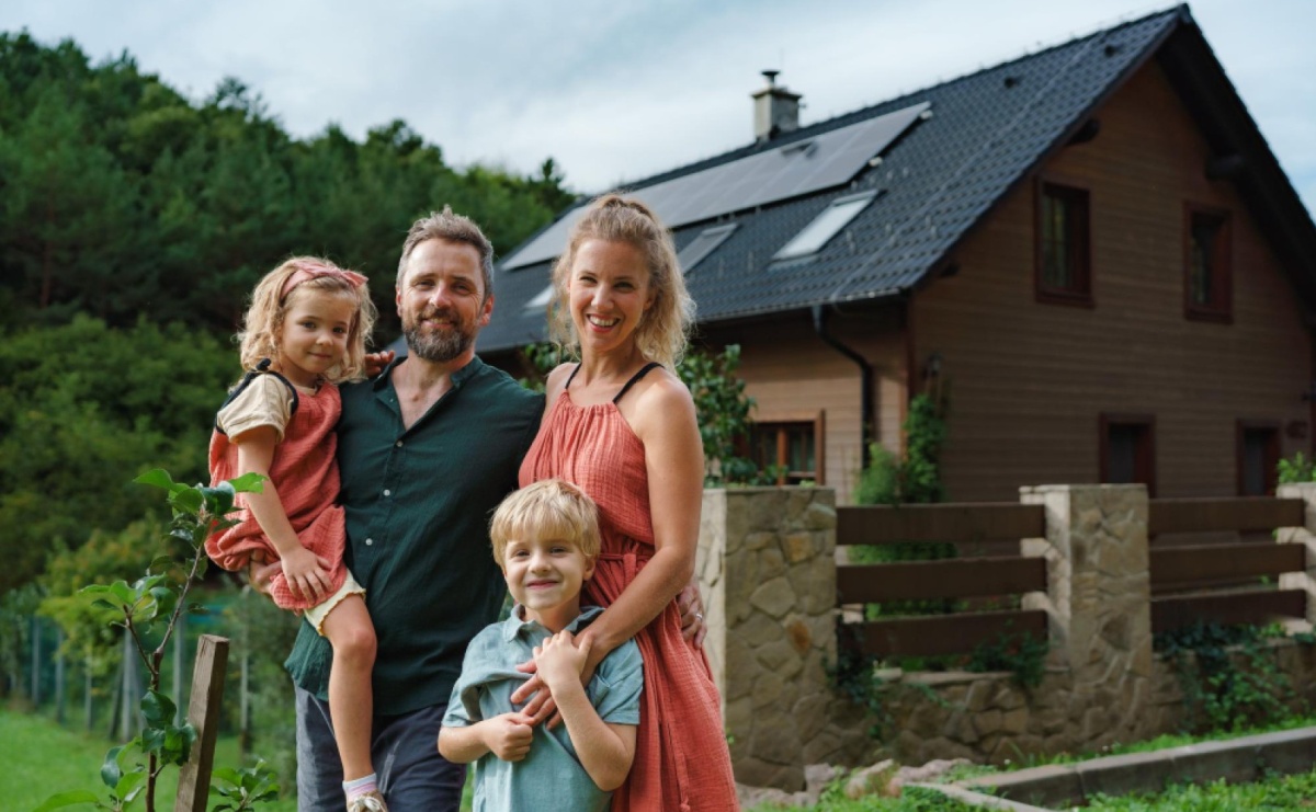 rodzina stojąca przed domem w stylu skandynawskim