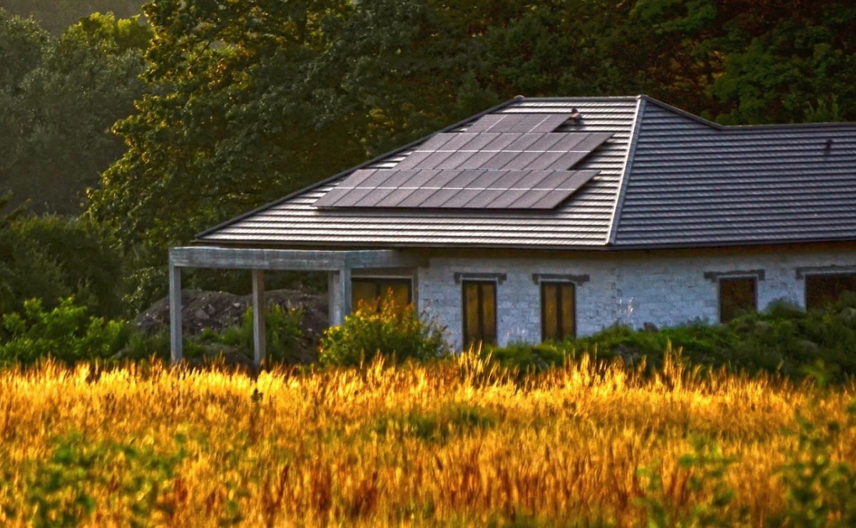 Instalacja fotowoltaiczna na dachu domu jednorodzinnego otoczonego zielenią